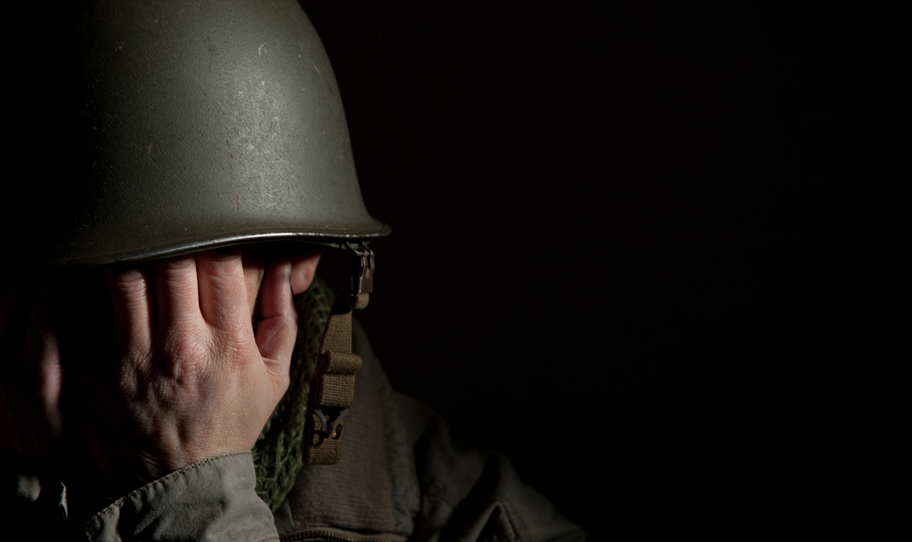 image of a soldier with his head down and feeling overwhelmed